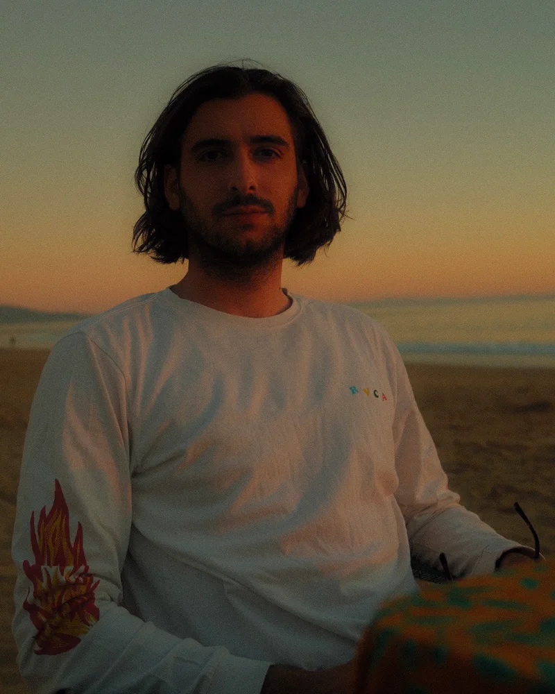 Portrait de Thomas Gonçalves sur une plage, au coucher du soleil.