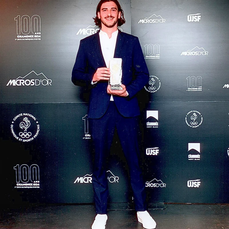 Thomas Gonçalves, son trophée en main, devant le mur des partenaires des Micros d’Or.
